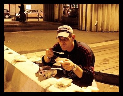 Immigration. Poverty. Men eating. Free meal from Caritas
